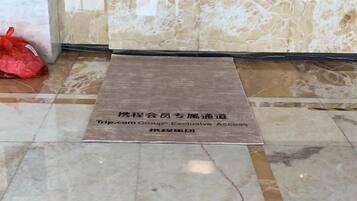 Un tapis avec un texte indiquant qu’il s’agit d’une zone d’accès réservée aux clients des hôtels du groupe Trip.com.