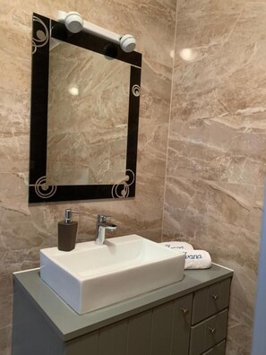 A bathroom with a white sink, a black-framed mirror, and a marble-tiled wall. - Imotski Blaue See Apartments , Pool (Imotski)