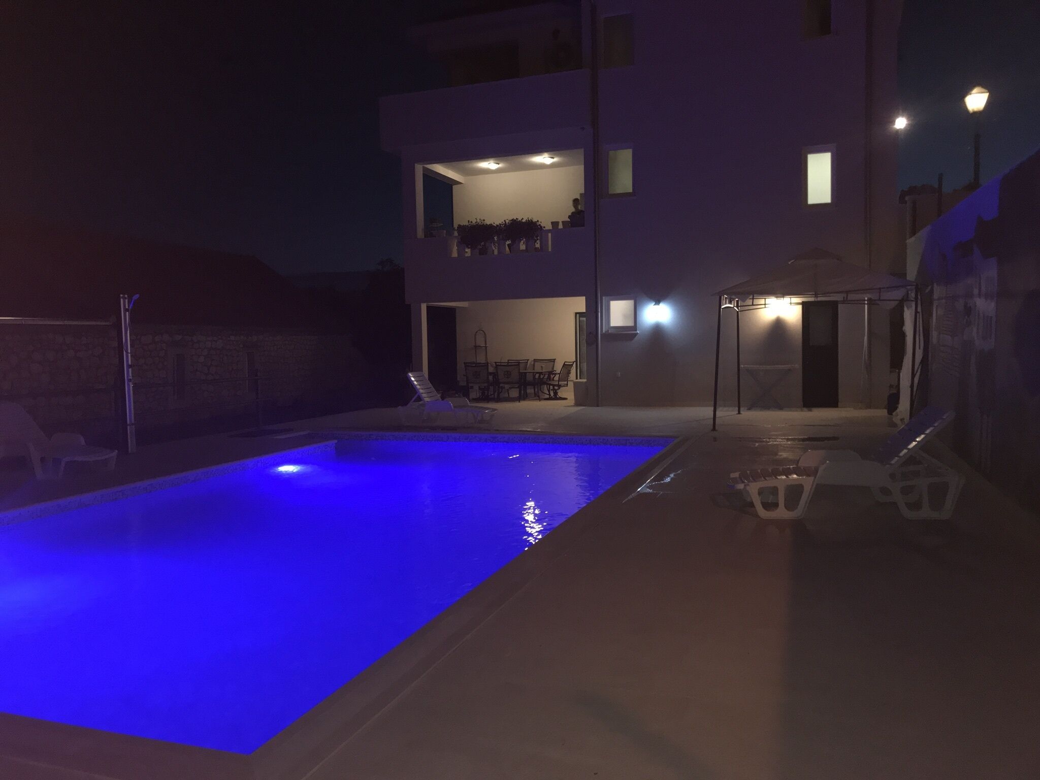 A modern two-story building with a swimming pool in the foreground.