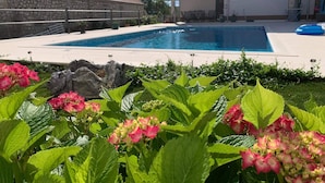 A swimming pool surrounded by lush greenery and a stone building. - "imotski Blaue See Apartments , Pool" (Imotski)