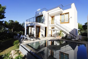 A modern two-story house with a glass-enclosed swimming pool, outdoor seating, and a staircase leading to the upper floor. - Villa Venere, 6 Bedrooms 5 Bathrooms, Private Pool and sea (Altavilla Milicia)