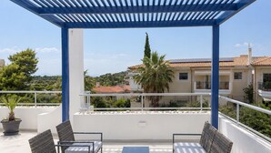 A covered outdoor seating area with a pergola, a table, and two chairs. - Adelos Maisonette Near Vouliagmeni Beach (Vari-Voula-Vouliagmeni)