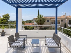 A covered outdoor seating area with a pergola, a table, and two chairs. - Adelos Maisonette Near Vouliagmeni Beach (Vari-Voula-Vouliagmeni)