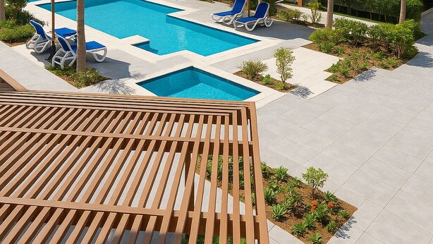 Ein modernes Hotel mit Pool, Liegestühlen und Palmen.