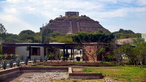 A large pyramid-like structure with a modern building in the foreground.