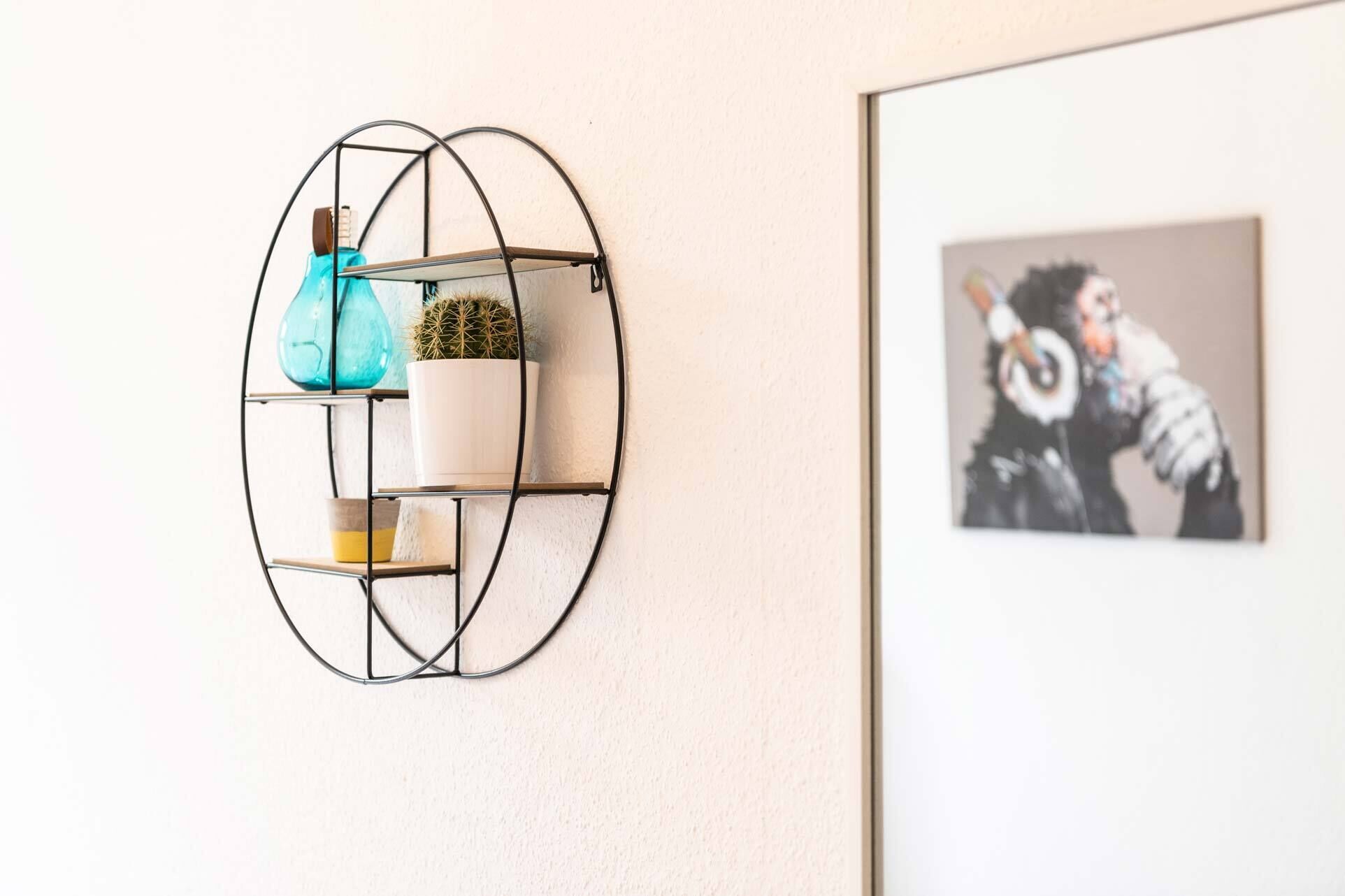 A wall-mounted shelf with decorative items and a framed picture.