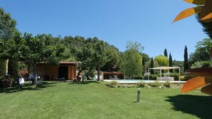 A well-maintained grassy yard with a small building, a pool, and a pergola. - Captivating 1-bed Villa With Pool in Tuscany (Palaia)