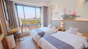 A hotel room with two beds, a large window with a view, a painting on the wall, and a small table with a chair. - Greentree Eastern Suzhou Industrial Park Expo Center Qingjianhu Union Square Hotel (Suzhou)