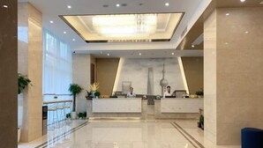 A modern hotel lobby with a reception desk, large windows, and a chandelier. - Greentree Eastern Suzhou Industrial Park Expo Center Qingjianhu Union Square Hotel (Suzhou)