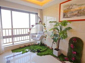 A room with a hanging chair, a potted plant, and a decorative wall piece.