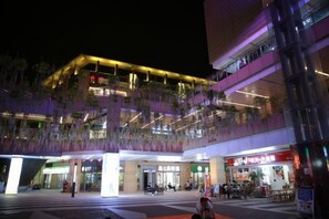 A modern building with multiple floors, large windows, and a covered outdoor area with seating. - Greentree Eastern Suzhou Industrial Park Expo Center Qingjianhu Union Square Hotel (Suzhou)