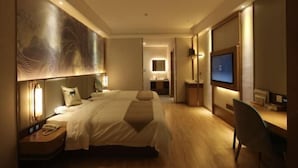 A hotel room with two beds, a desk with a computer, a TV, and a large artwork on the wall. - Greentree Eastern Suzhou Industrial Park Expo Center Qingjianhu Union Square Hotel (Suzhou)