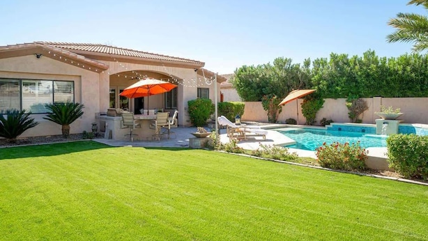 A backyard with a swimming pool, a patio with outdoor furniture, and a well-maintained lawn. - Camelback Corridor, 5 min from Airport, Pool & Sun (Phoenix)