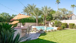 A backyard with a pool, patio furniture, and palm trees. - Camelback Corridor, 5 min from Airport, Pool & Sun (Phoenix)