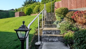 A set of stone steps leading up to a wooden fence with a star decoration on top. - Lavender Cottage (Castletownbere)