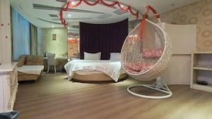 Quarto com cama, cadeira suspensa, escrivaninha e poltrona.