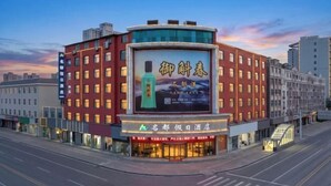 Um hotel com um grande letreiro, vários andares e design moderno.