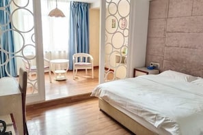 Une chambre à coucher comprenant un lit, une chaise, une petite table et un panneau décoratif mural.