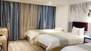 A hotel room with two beds, a desk, and a large window with curtains. - Mingdu Holiday Hotel (Xiayi County)