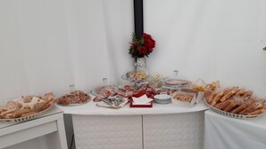 Una mesa de bufé con diferentes platillos y un jarrón de flores.