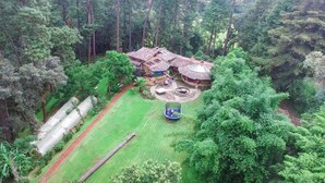 A secluded lodge surrounded by dense forest, featuring a circular patio with a trampoline, a small pool, and a thatched-roof structure. - Country House In The Woods With River (Valle de Bravo)