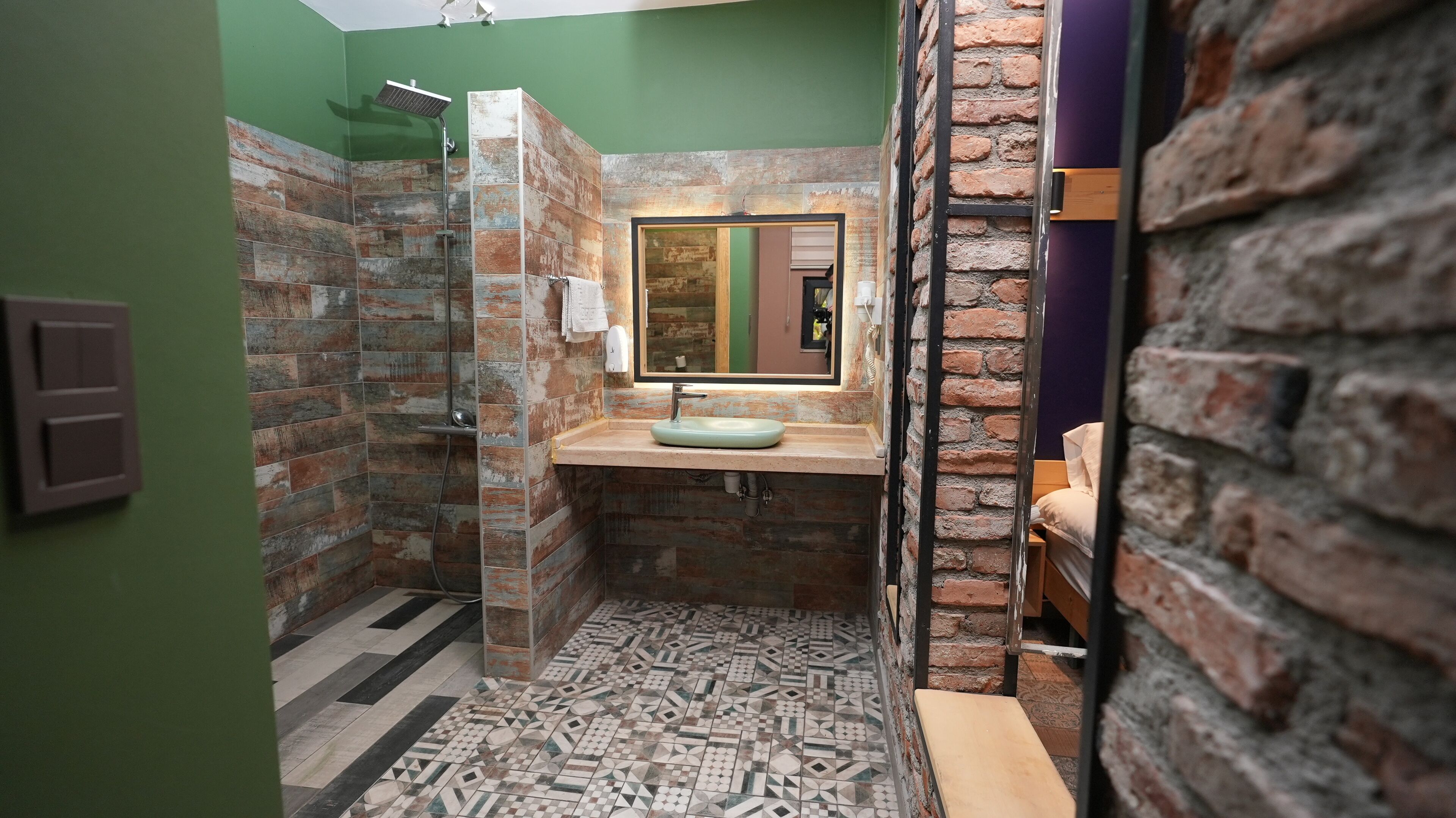 Ein Badezimmer mit Dusche, Waschbecken und Spiegel.