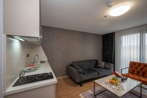 Suite – deluxe, flere senger | Oppholdsområde | En 32-tommers LED-TV med Parabol-TV samt TV og Netflix