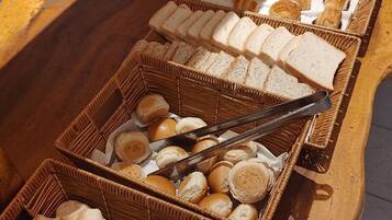 A buffet with various baked goods and bread.