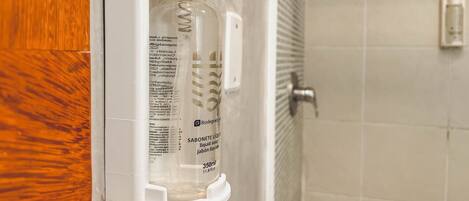 Baño con dispensador de jabón blanco montado en la pared.