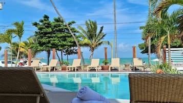 Una piscina al aire libre, sillones reclinables de piscina