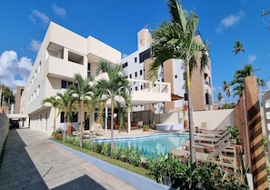 Relax by the pool surrounded by palm trees and lounge chairs.