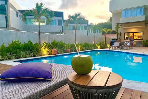 Una piscina al aire libre, sillones reclinables de piscina