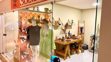 A store with mannequins, a display table with hats, and a sign reading 'Razz.'