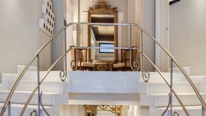 Eine prächtige Treppe mit aufwendiger Metallgalerie, die zu einem Balkon im zweiten Stock führt.