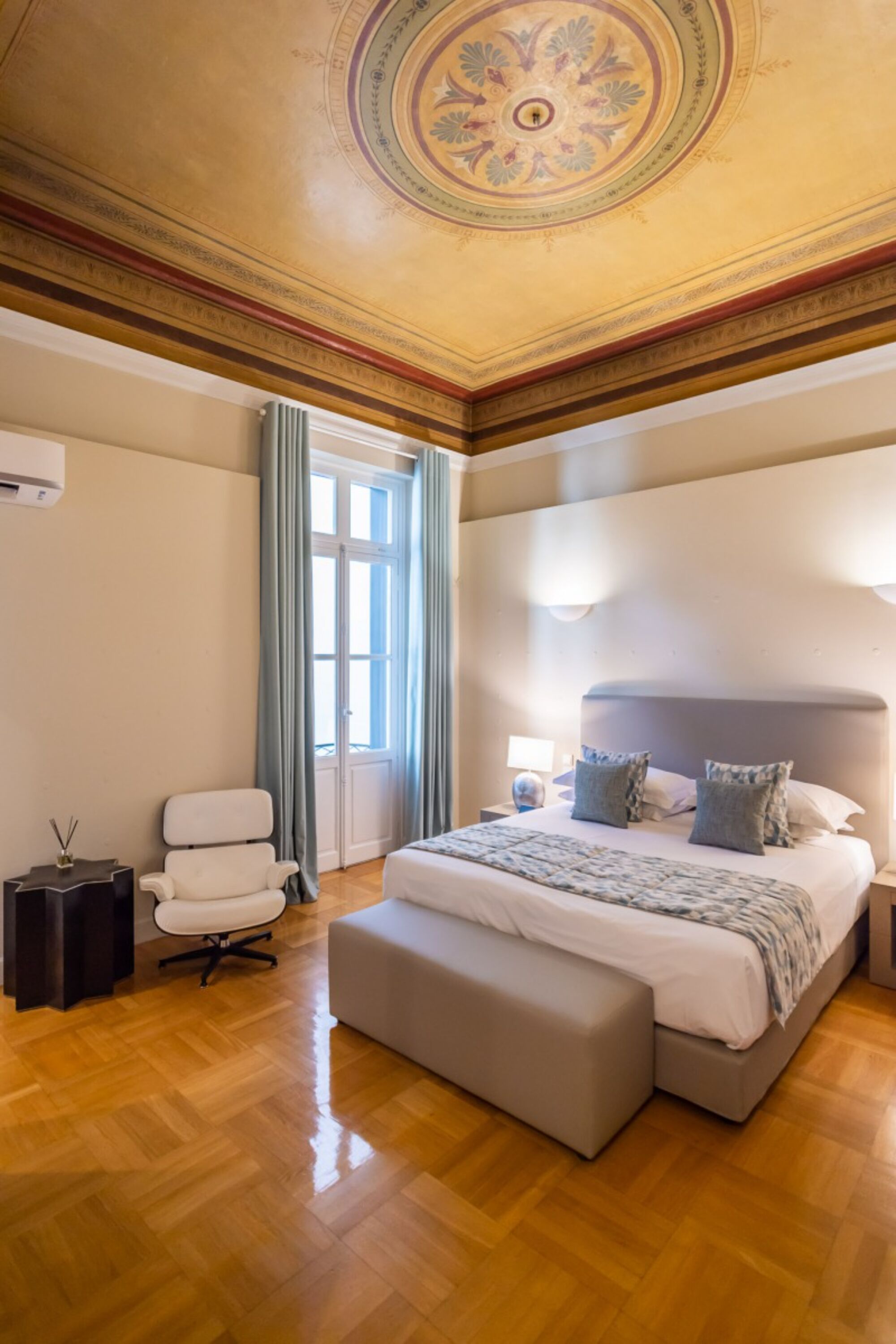 A spacious bedroom with a large bed, a chair, and a desk.