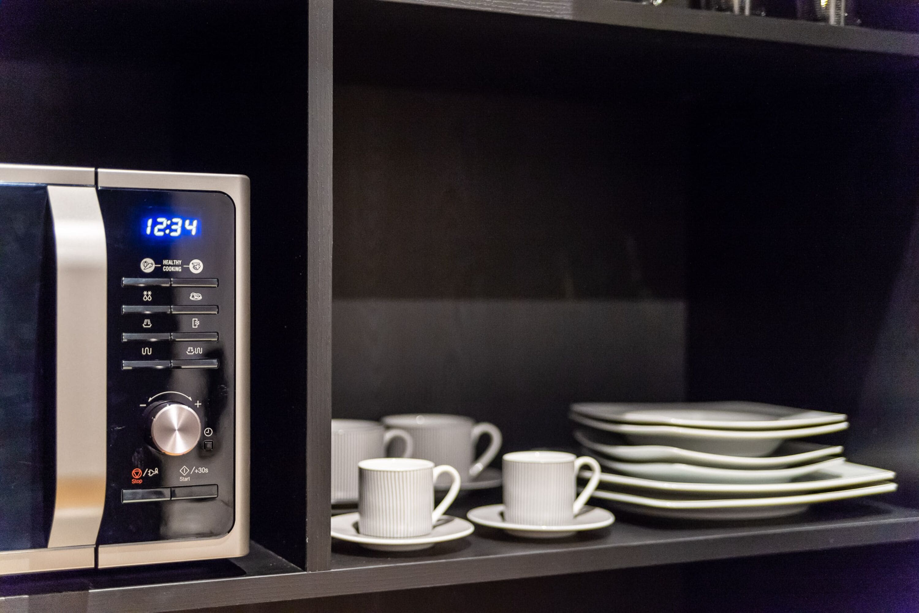 A microwave with a digital display, control buttons, and a timer.