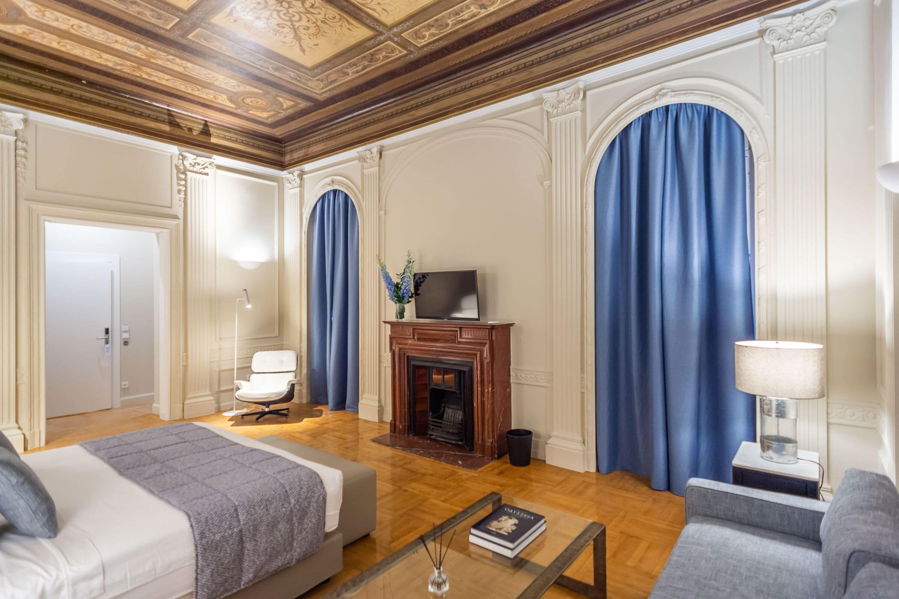 A spacious room with a fireplace, a television, and a bed.