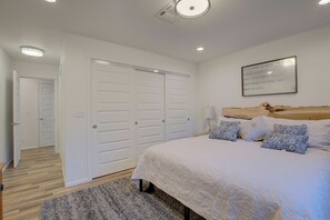 A bedroom with a large bed, white walls, and a ceiling light. - 3 Bedroom, 2 Bath, Clean, Bright, Modern Space, in a Quite, Modest Neighborhood  (Grants Pass)