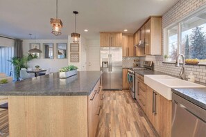 Une cuisine moderne avec des armoires en bois, des appareils en acier inoxydable et un grand îlot central.