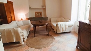 Uma sala de estar acolhedora com dois sofás, uma mesa de centro e uma luminária.