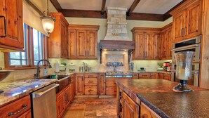 A spacious kitchen with wooden cabinets, a stone backsplash, and a central island.