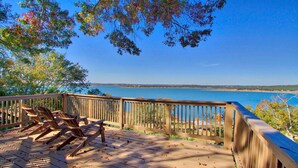 A wooden deck with chairs overlooking a body of water.
