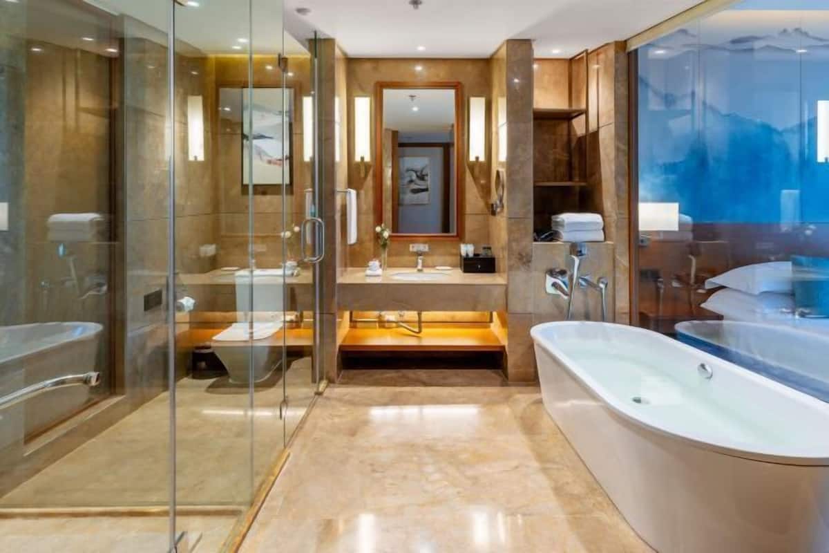 Une salle de bain moderne avec une douche à parois de verre, une grande baignoire et un meuble-lavabo avec un miroir.