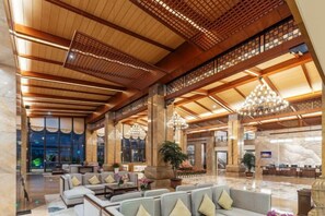 A spacious lobby with high ceilings, a grand chandelier, and a seating area with sofas and armchairs. - Yongchang Hotel (Baoshan)