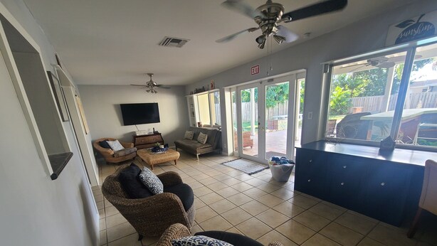 A living room with wicker furniture, a flat-screen TV, and a view of the outside. - Hollywood getaway near all points of interest (Hollywood)
