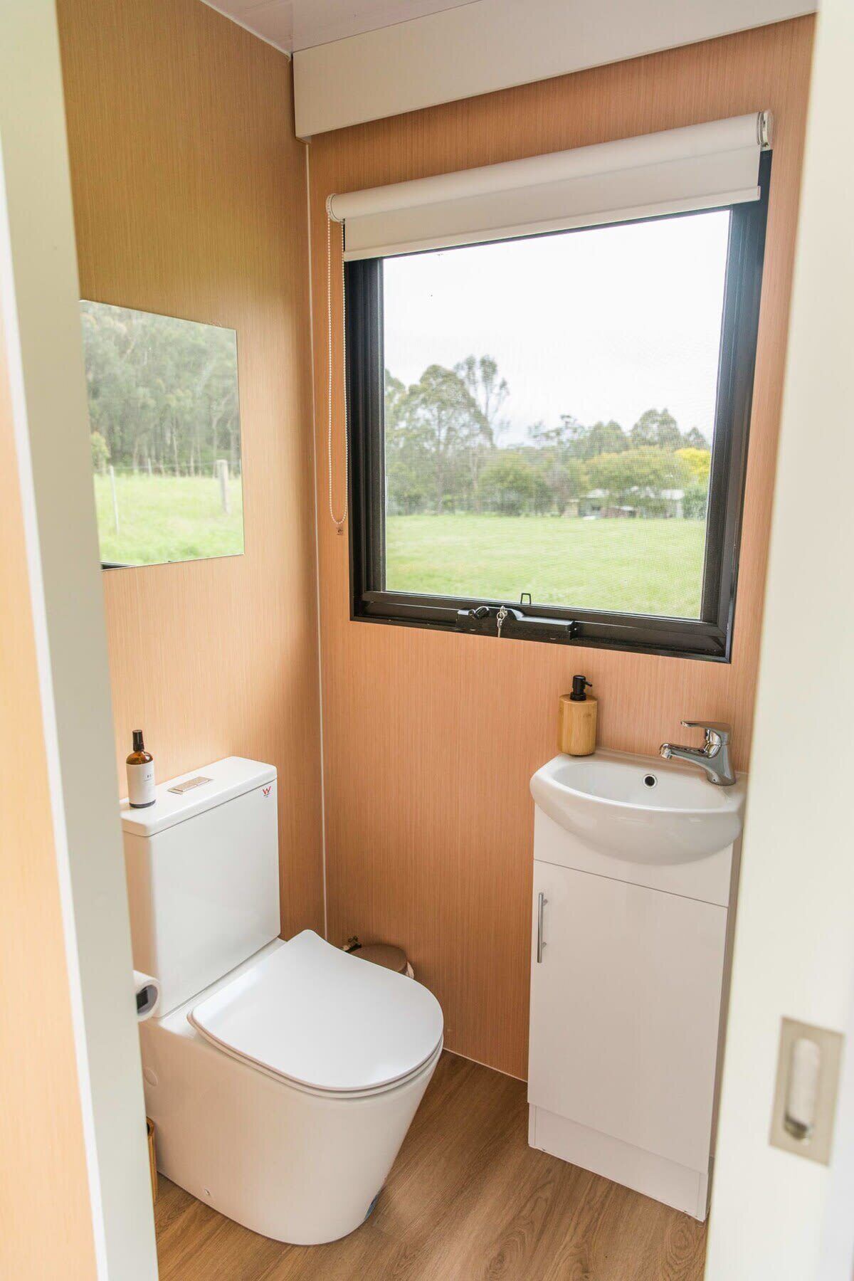 A compact bathroom with a toilet, sink, and window.