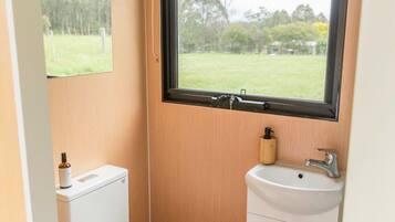 A compact bathroom with a toilet, sink, and window.