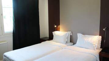 TvÄbÀddsrum - 2 enkelsÀngar - utsikt mot trÀdgÄrden | 1 sovrum, vÀrdeförvaringsskÄp pÄ rummet och arbetsyta för laptop