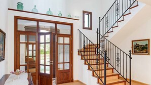 Una escalera con peldaños de madera y barandillas de metal negro que conduce a un piso superior.