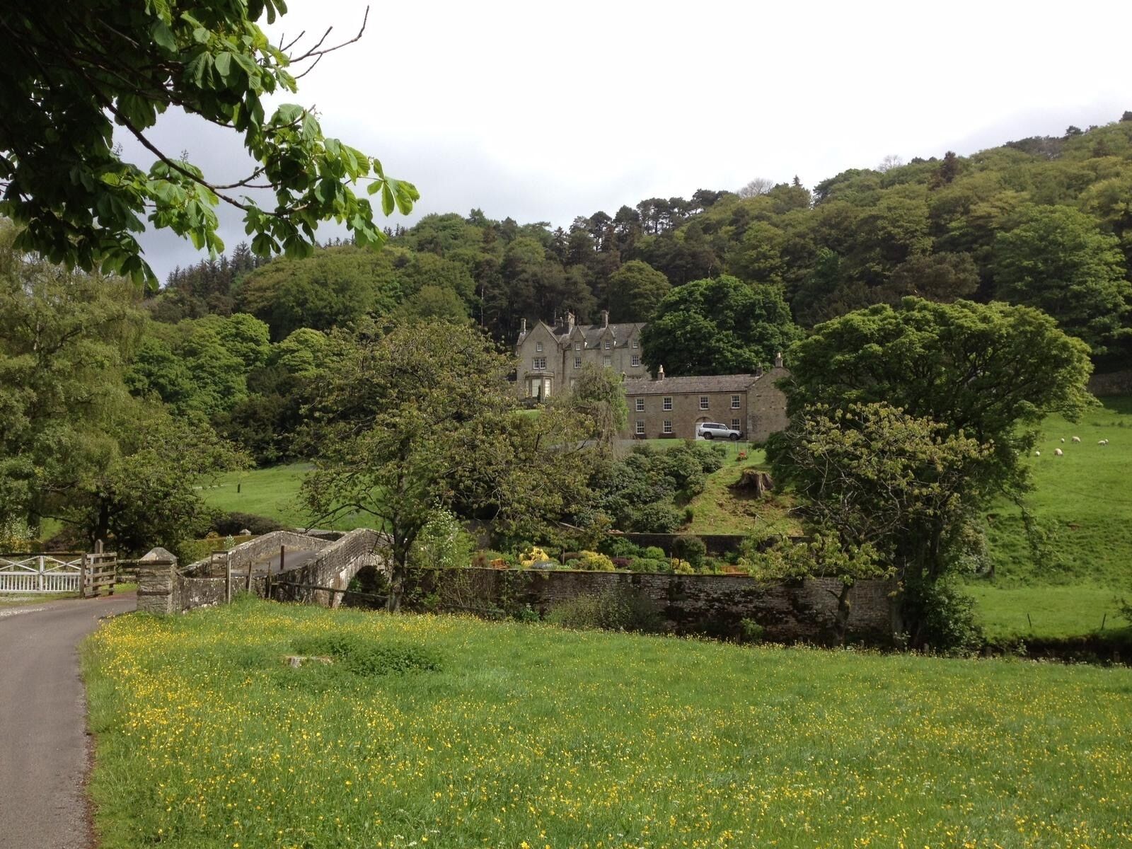 A historic stone house with a stone bridge in the foreground.